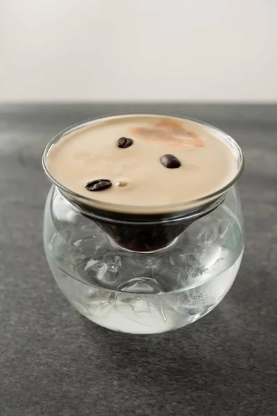 Вертикальний знімок вишуканої дизайнерської чашки кави з кавовими зернами та розмитим фоном — стокове фото