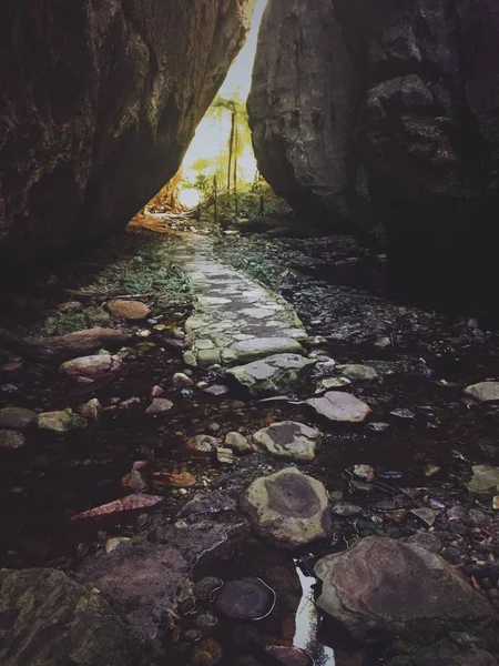 Вертикальний знімок ставка з камінням і стежкою посеред двох скель — стокове фото