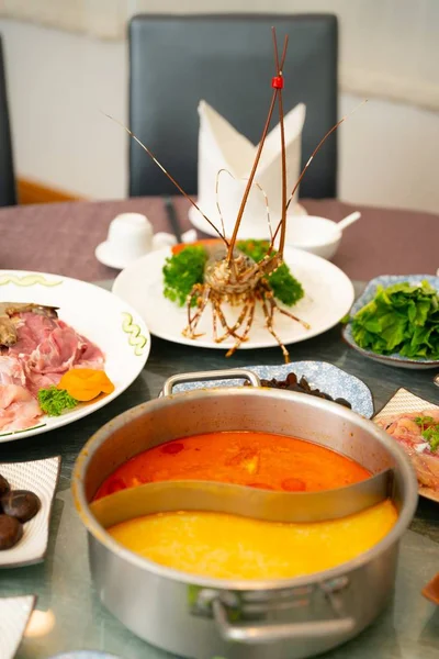 Vertical shot of a lobster near a soup with a side dishes — Stock Photo, Image