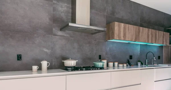 Интерьер современной кухни с кухонными плитами на духовке и другими кухонными принадлежностями — стоковое фото
