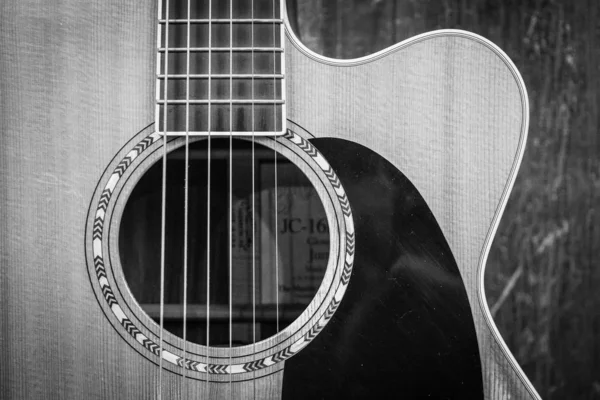 Närbild gråskala skott av en soundhole av en akustisk gitarr — Stockfoto