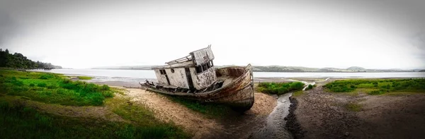 Gyönyörű panoráma felvétel a tó partjáról egy roncs hajóval a szárazföldön — Stock Fotó