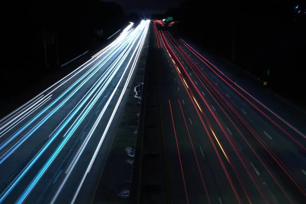 Fotografia aérea de uma estrada rodoviária com trilhas de velocidade de luz do carro — Fotografia de Stock