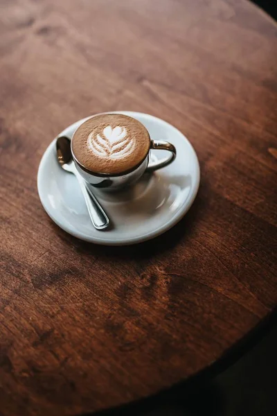 Prachtig gemaakte cappuccino geserveerd met bloemsierkunst op de Foam shot van bovenaanzicht — Stockfoto