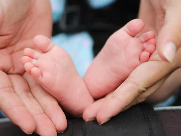 Primo piano colpo di dita dei piedi del bambino tenute nelle mani dei genitori — Foto Stock