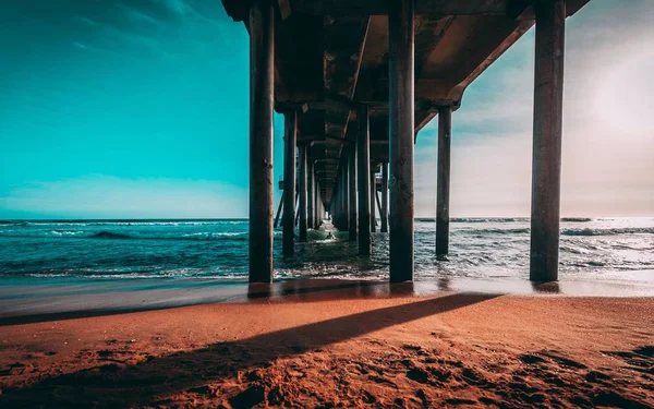 美しい海の海岸にある木製の長い桟橋の下の領域 — ストック写真