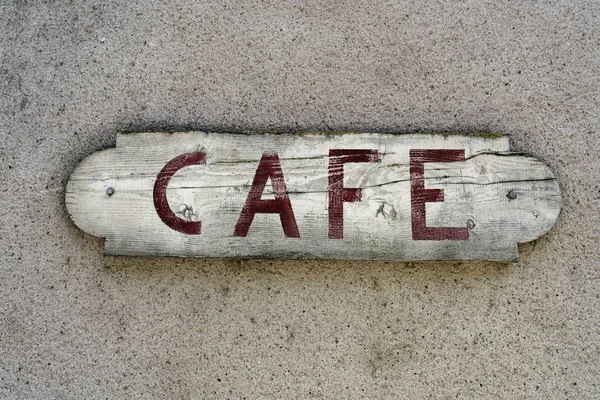 Близкий снимок деревянного знака кафе, прибитого к стене — стоковое фото