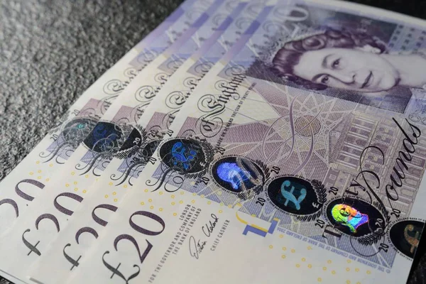 Closeup shot of twenty-pound sterling bills on a gray background — Stock Photo, Image