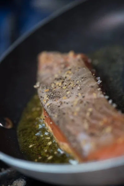 Plan vertical d'un poisson frit dans une casserole avec un fond flou — Photo