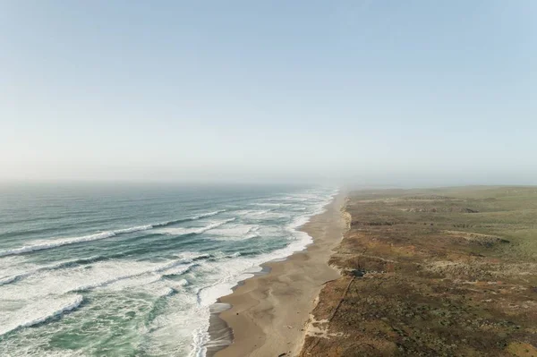 Schöne Weitwinkelaufnahme des Ozeans in der Nähe einer Wüste unter einem klaren blauen Himmel — Stockfoto