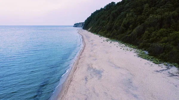 一张美丽的海滩照片 靠近一座森林覆盖的山 — 图库照片