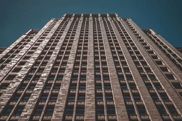 Vista de bajo ángulo de un edificio de negocios alto con un fondo azul oscuro —  Fotos de Stock