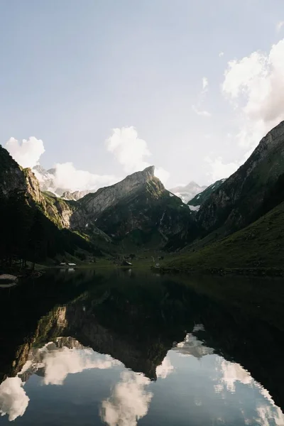 맑은 하늘 아래 호수에 반사되어 있는 산 과언 덕의 모습 — 스톡 사진