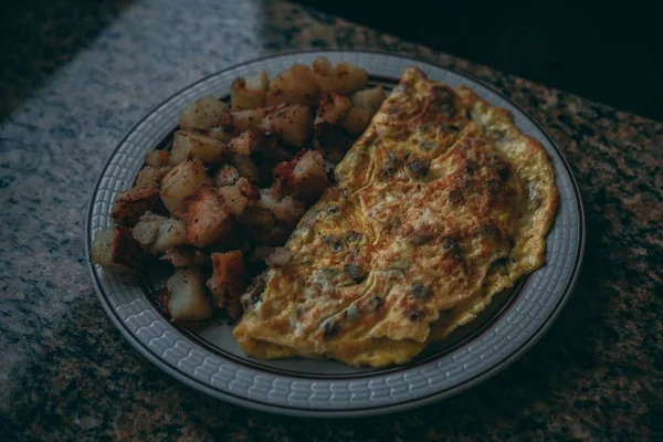 Close-up shot van een omelet en varkensvlees op een bord — Stockfoto