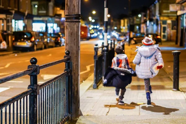 Широкий Снимок Двух Маленьких Детей Прыгающих Тротуару Ночью — стоковое фото