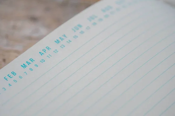 Libro de texto azul abierto con marcadores de fecha en la parte superior sobre una superficie de madera — Foto de Stock