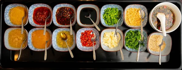 High angle shot of different spices and sauces in different bowls — Stock Photo, Image