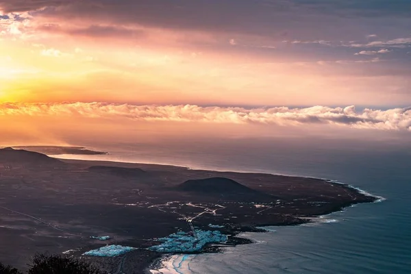 Luchtfoto van een prachtige kuststad aan de kust met verbazingwekkende wolken en zonlicht aan de linkerkant — Stockfoto