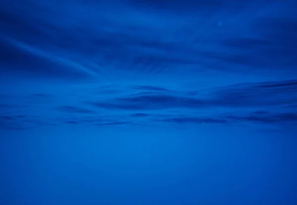 Amplo tiro de um belo campo nevado com deslumbrante céu azul nublado no fundo — Fotografia de Stock