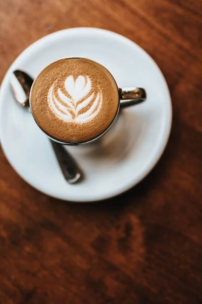 Bellamente hecho capuchino servido con el arte de la flor en el tiro de espuma de vista aérea — Foto de Stock