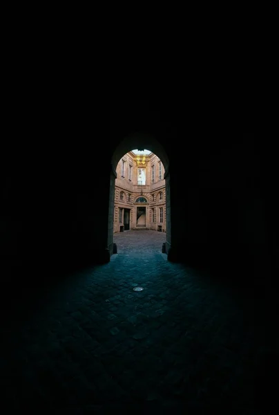 Dark hallway with arched doorway with a view of a concrete building — Stock Photo, Image