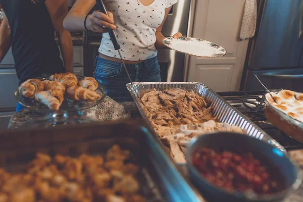 Opname van een persoon die voedsel opplust uit een tafel gevuld met vlees en gebak — Stockfoto