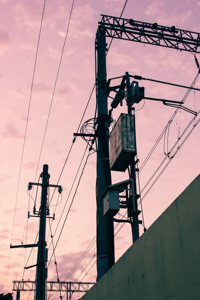 Telefone e linhas de eletricidade com céu rosa bonito — Fotografia de Stock