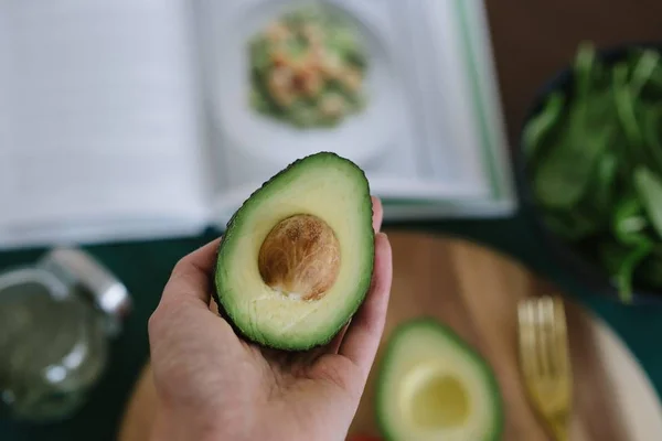 Närbild av en person som innehar en avokado — Stockfoto