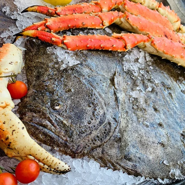Closeup of a big fish near crab legs on the ice — Stock Photo, Image