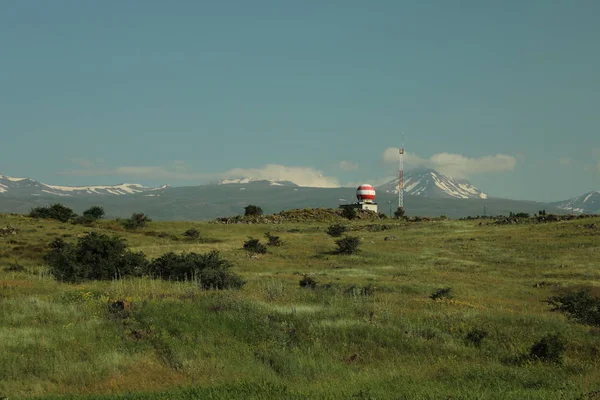 Een Radiotoren Een Veld Met Een Berg Achtergrond — Stockfoto