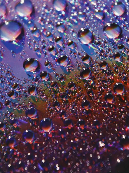 Belo closeup de gotas de água em uma janela com luzes frescas coloridas surpreendentes — Fotografia de Stock