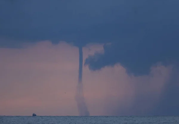 Dissipating water-spout in front of a rain-front in the early morning. Off Mellieha Bay, Malta, Central Mediterranean.