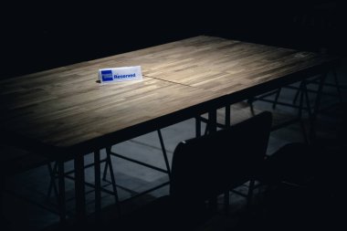 A table in a dark room with a sign 