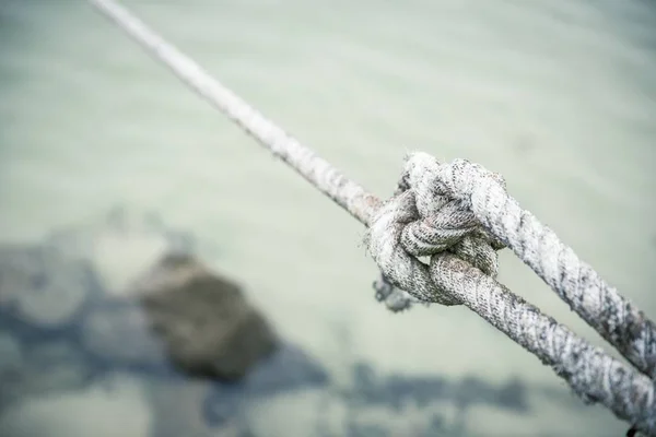 Fechar de um nó firmemente amarrado com uma corda branca amarrada por um pescador — Fotografia de Stock