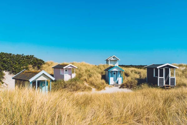 Drewniane domy i chaty w suchym polu trawiastym z błękitnym bezchmurnym niebem w tle — Zdjęcie stockowe