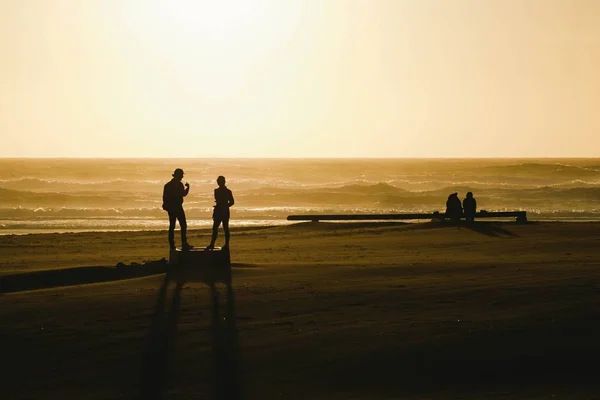 Silhouetten van mensen op het strand — Stockfoto