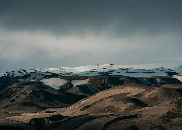 Vacker natur med snöiga kullar och mörk grå himmel — Stockfoto