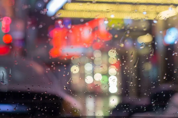 Primer plano de gotas de lluvia sobre vidrio con luces borrosas de la ciudad en el fondo de la ciudad de Nueva York — Foto de Stock