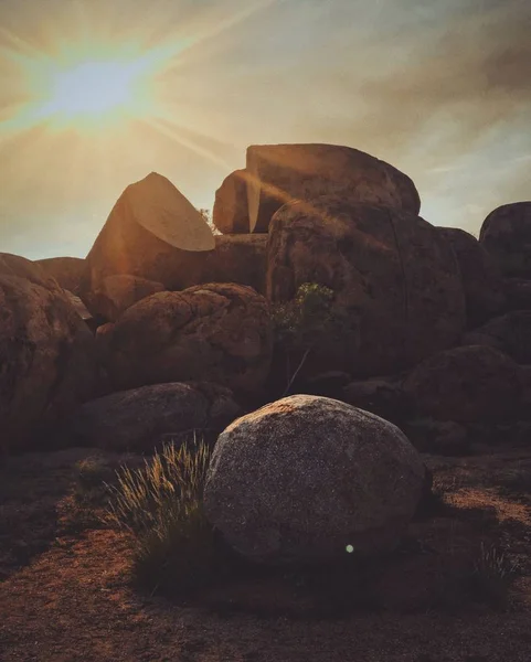 Vertikale Aufnahme eines Felsens mit der Sonne am Himmel — Stockfoto