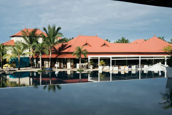 Vista para a piscina do hotel com palmeiras e espreguiçadeiras — Fotografia de Stock