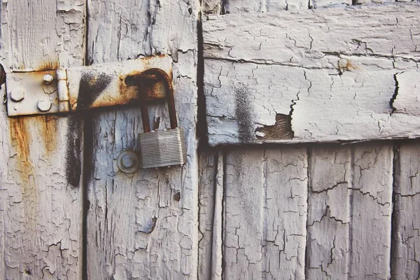 木製の風化した白いドアの錆びた古い南京錠のクローズアップショット — ストック写真