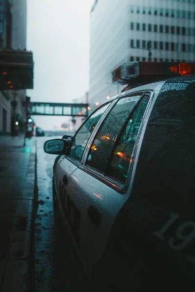 Вертикальный крупный план полицейской машины, припаркованной на дождливой дороге — стоковое фото