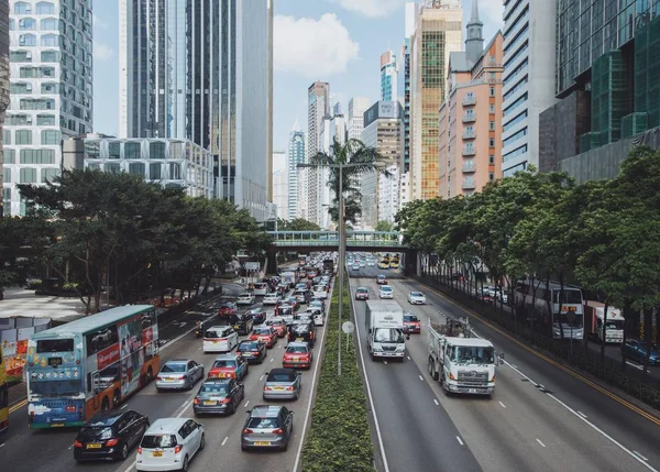 Disparo lejano de coches y otros vehículos en una carretera cerca de árboles y edificios — Foto de Stock