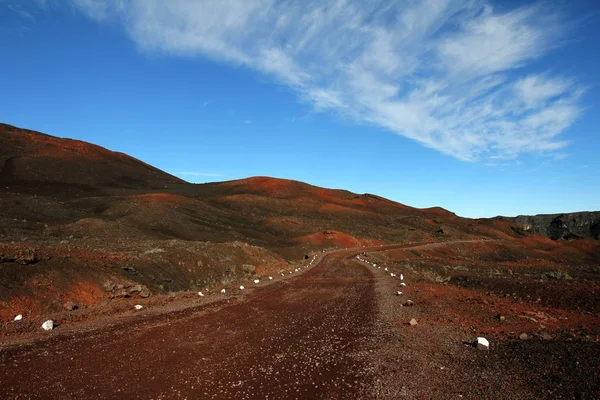 Dirt road közepén elhagyatott dombok alatt a kék ég — Stock Fotó