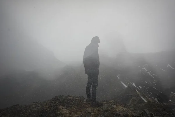 A cool man standing on the edge of a foggy mountain — Stock Photo, Image