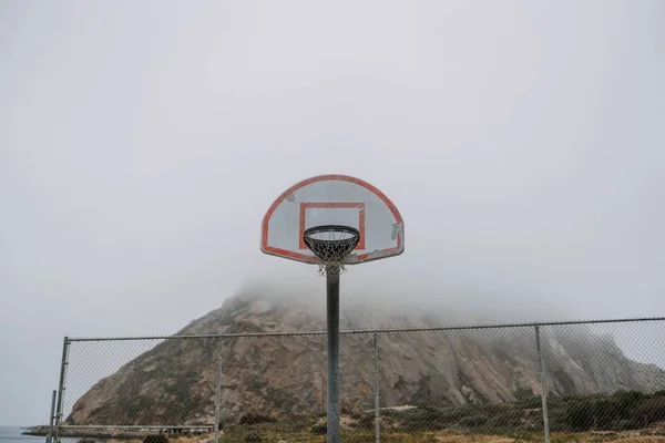 Girato di un cerchio di pallacanestro su un backboard vicino a montagna — Foto Stock