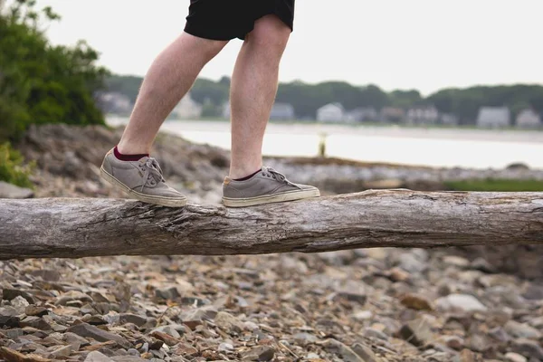 Erkek ayakları ahşap bir tahta üzerinde dengeleme — Stok fotoğraf