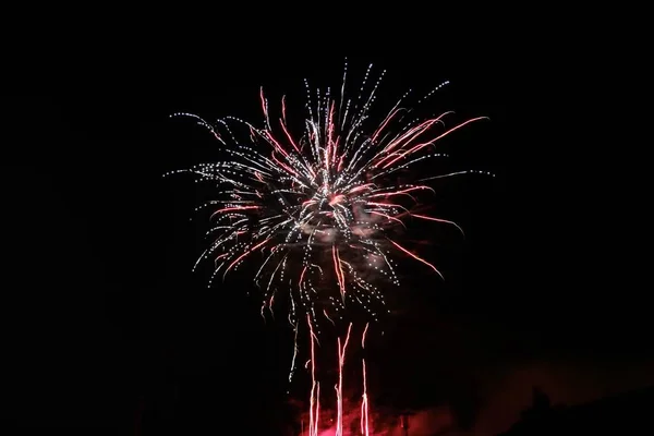 Belo tiro de fogos de artifício coloridos em erupção e estourando no céu noturno — Fotografia de Stock