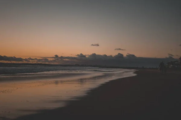 黄昏时分在美丽的沙滩上散步的老年人 — 图库照片