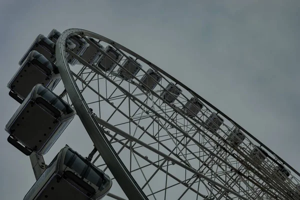 Nízký úhel široký záběr prázdného kola Ferris během deštivého oblačníku v parku — Stock fotografie